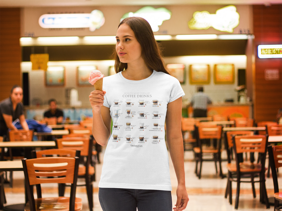 woman in a cafe wearing world's most popular coffee drinks poster t-shirt