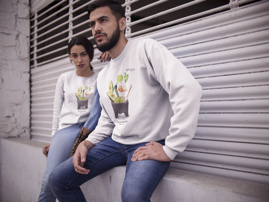 a couple sitting outside wearing guacamole sweatshirts