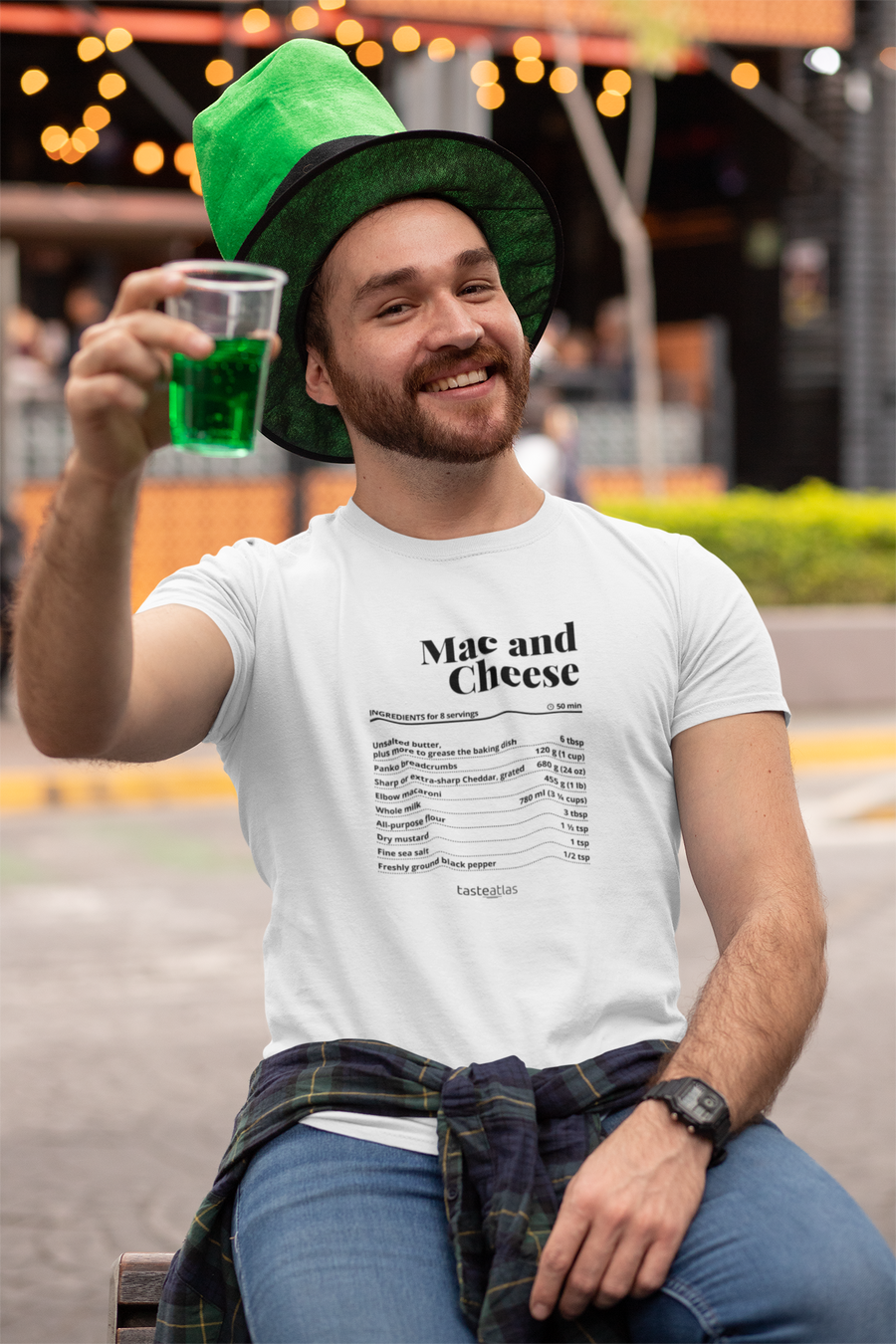 a man in front of a bar wearing mac and cheese recipe t-shirt