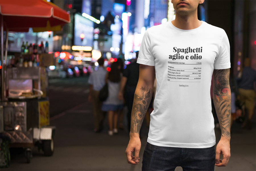 a man on a street during the night wearing spaghetti aglio e olio recipe t-shirt